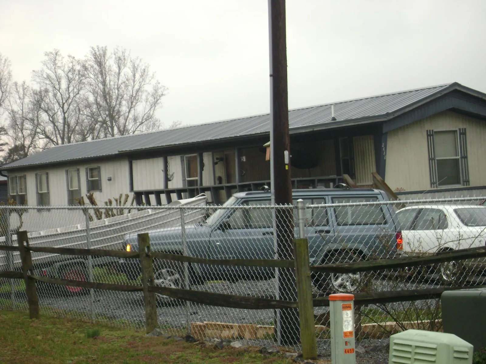 Dark metal roof on a long single story building behind a chain link fence in Elkton